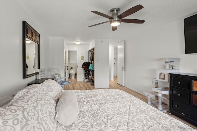 bedroom featuring light wood-type flooring, connected bathroom, and ceiling fan