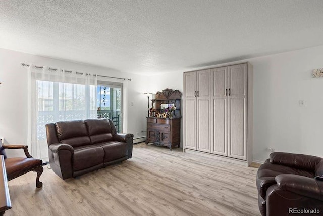 living area with light wood-style floors, a textured ceiling, and a baseboard radiator