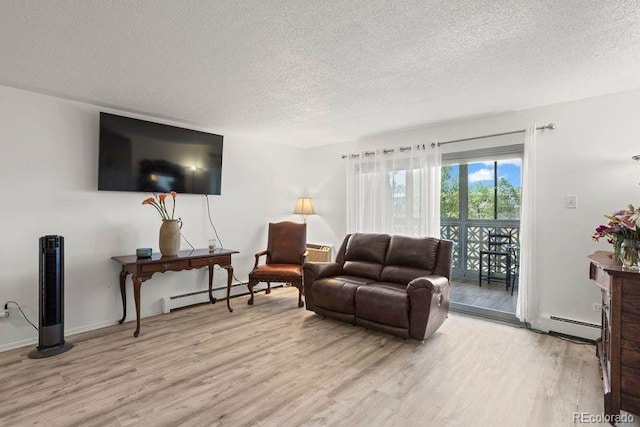 living area featuring a baseboard heating unit, a textured ceiling, and light wood-style floors