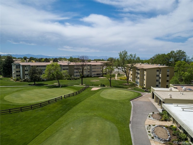 view of property's community featuring an area to practice putting and view of golf course