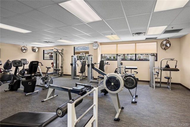 workout area with a paneled ceiling, carpet flooring, and baseboards