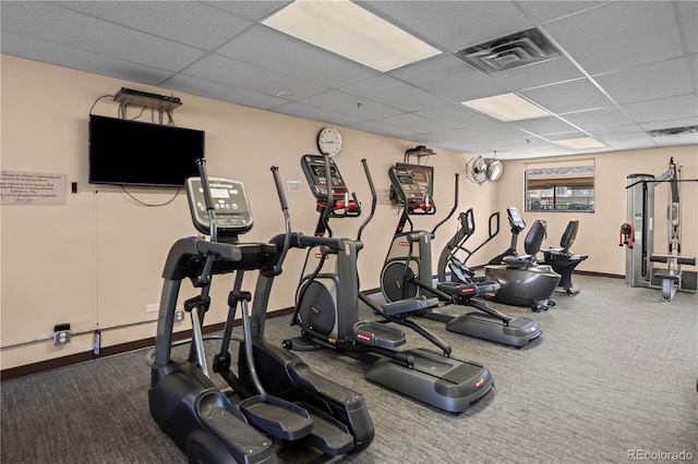 exercise room with a drop ceiling, carpet flooring, and baseboards