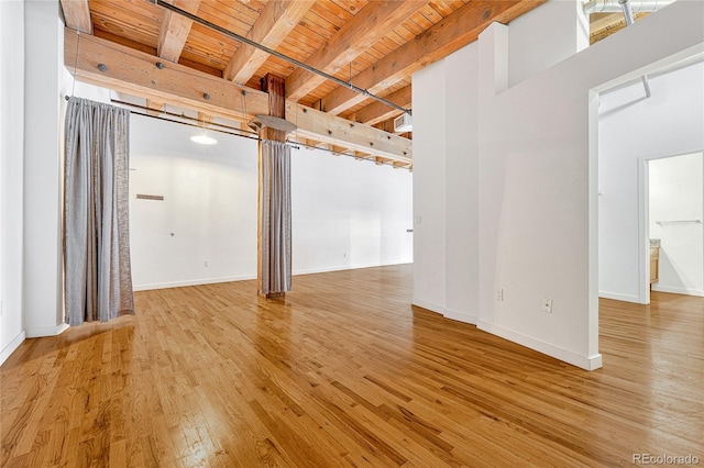 unfurnished room with beamed ceiling, hardwood / wood-style floors, and wood ceiling