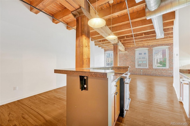 kitchen with light hardwood / wood-style flooring and brick wall