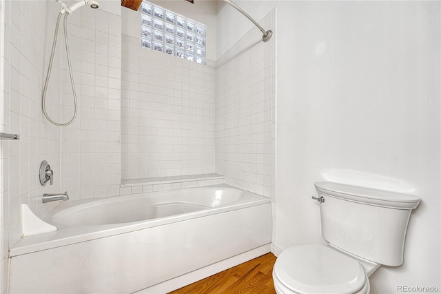 bathroom featuring toilet, hardwood / wood-style flooring, and tiled shower / bath