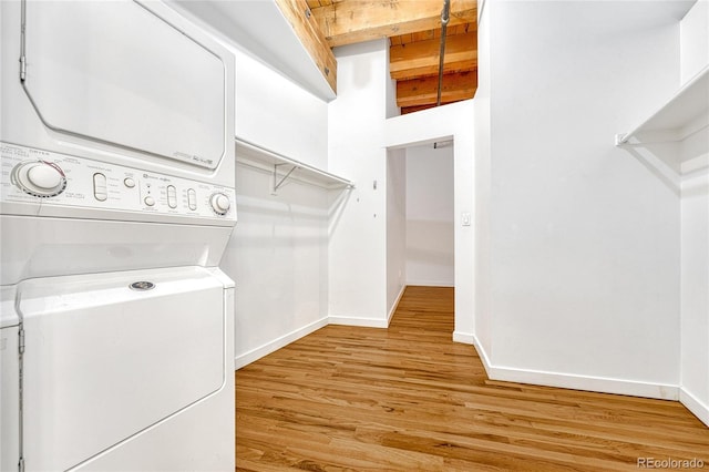 laundry area with light wood-type flooring and stacked washer and clothes dryer