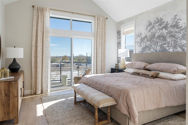 bedroom with access to exterior, hardwood / wood-style floors, and vaulted ceiling