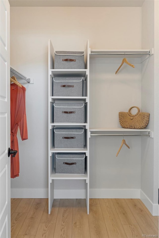 walk in closet with hardwood / wood-style floors