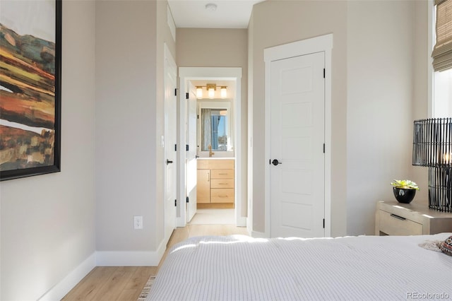 bedroom featuring ensuite bathroom and light hardwood / wood-style floors