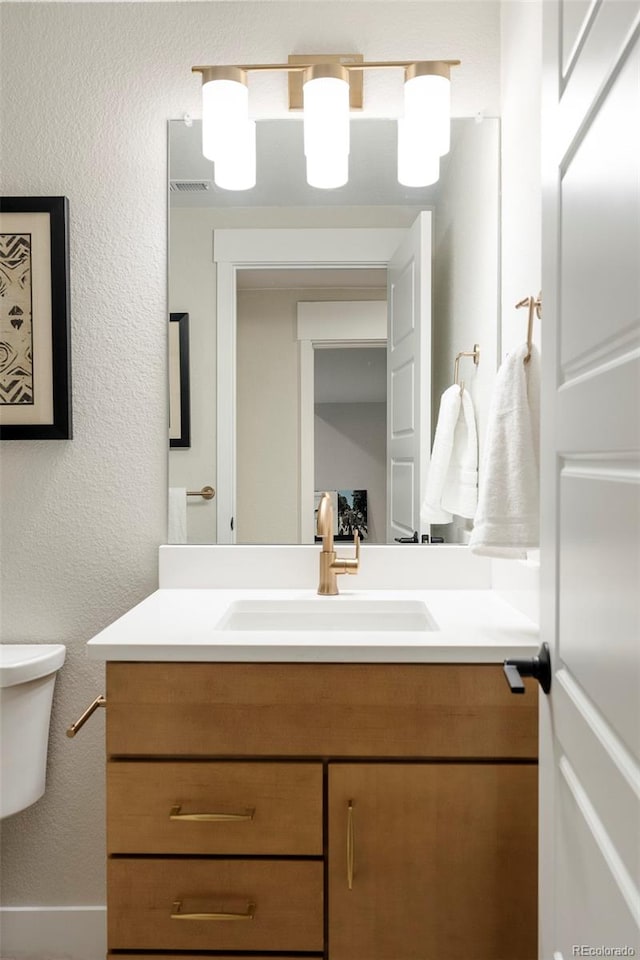 bathroom featuring vanity and toilet