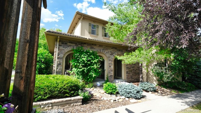 10328 Bluffmont Dr, Lone Tree, CO 80124 - mediterranean / spanish home featuring a tiled roof, stone siding, and stucco siding