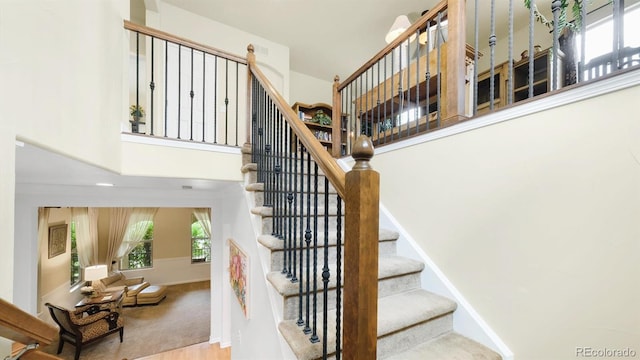 10328 Bluffmont Dr, Lone Tree, CO 80124 - stairway featuring a towering ceiling and baseboards