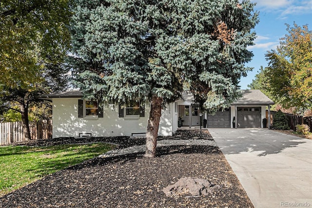 view of property hidden behind natural elements featuring a garage