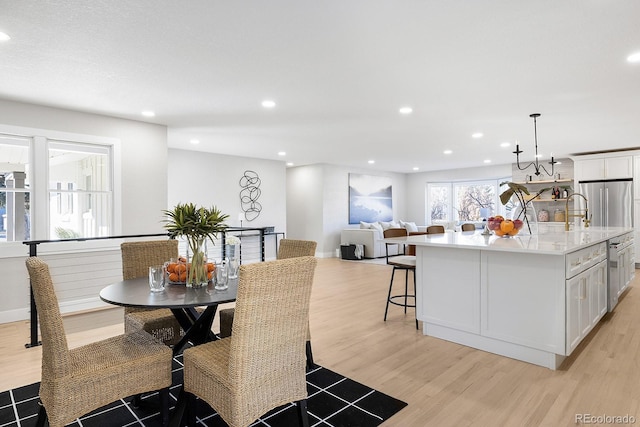 dining room featuring sink and light hardwood / wood-style floors