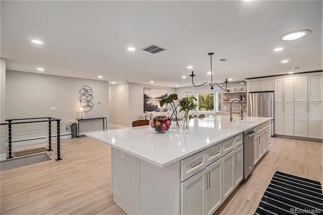 kitchen featuring a spacious island, decorative light fixtures, and light hardwood / wood-style floors