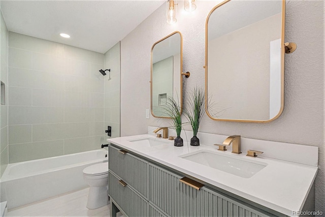 full bathroom featuring tiled shower / bath, vanity, and toilet