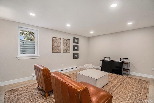 living room with baseboard heating and light hardwood / wood-style flooring