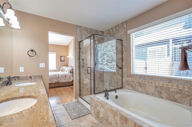 ensuite bathroom featuring a sink, a bath, and a shower stall