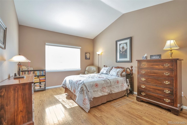 bedroom featuring light wood-type flooring, lofted ceiling, and baseboards