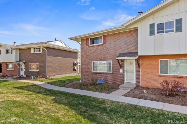 9044 E Nassau Ave, Denver, CO 80237 - view of front of house with board and batten siding, a front lawn, and brick siding