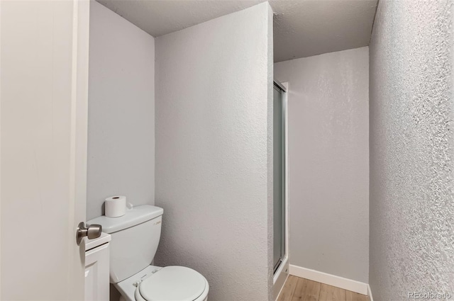 490 Washington Ave Unit A, Bennett, CO 80102 - full bath featuring wood finished floors, a stall shower, and toilet