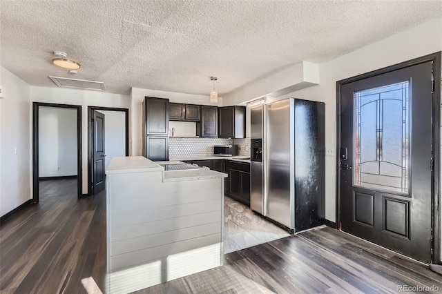 490 Washington Ave Unit A, Bennett, CO 80102 - kitchen with appliances with stainless steel finishes, light wood finished floors, light countertops, a center island, and a textured ceiling