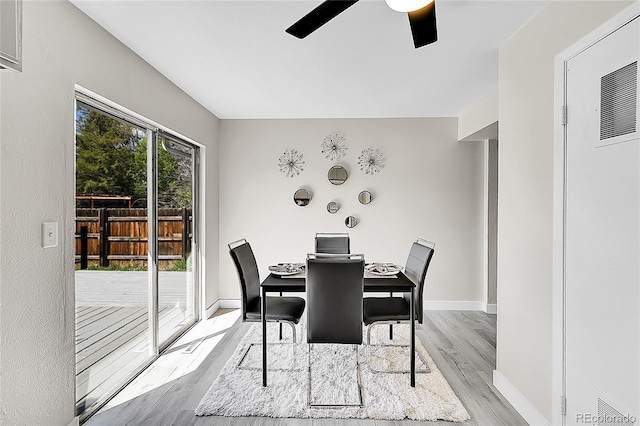 dining space featuring light wood-style flooring, ceiling fan, baseboards, and a heating unit