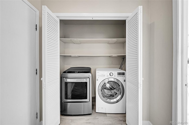 laundry area with separate washer and dryer and light wood-style flooring