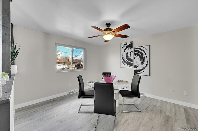dining room featuring wood finished floors, a ceiling fan, and baseboards