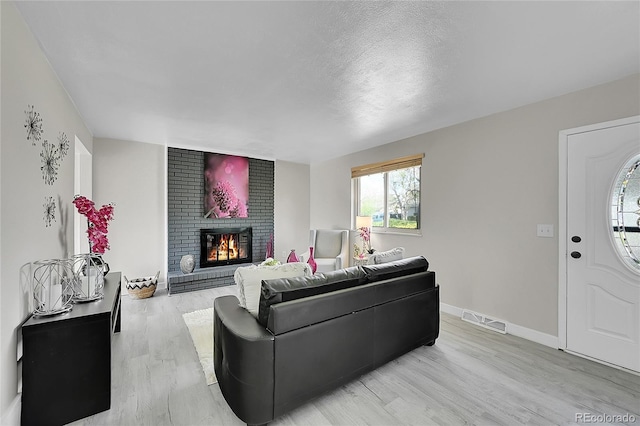 living area with light wood-style flooring, a fireplace, and baseboards