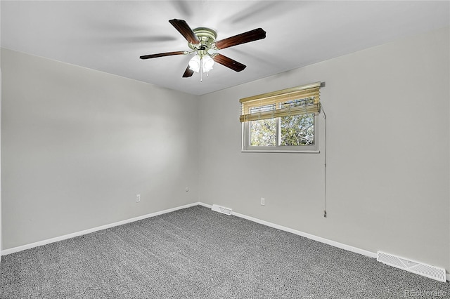 empty room with a ceiling fan, dark carpet, and baseboards
