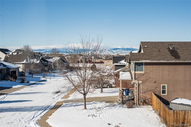 yard layered in snow featuring a mountain view