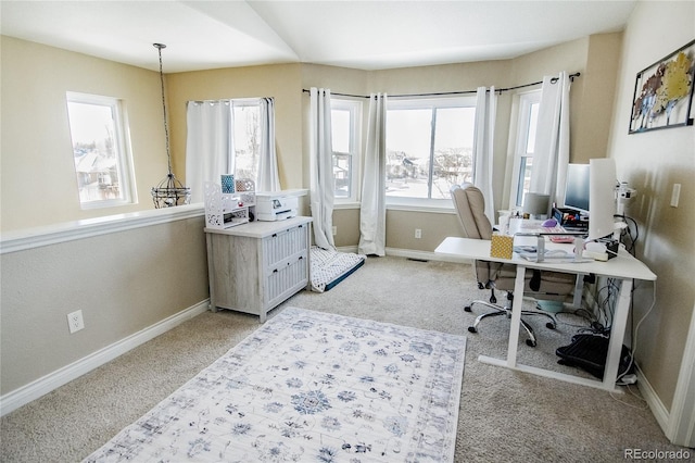 carpeted office space featuring lofted ceiling and a healthy amount of sunlight