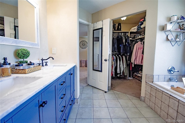 bathroom featuring vanity, tiled bath, and tile patterned floors