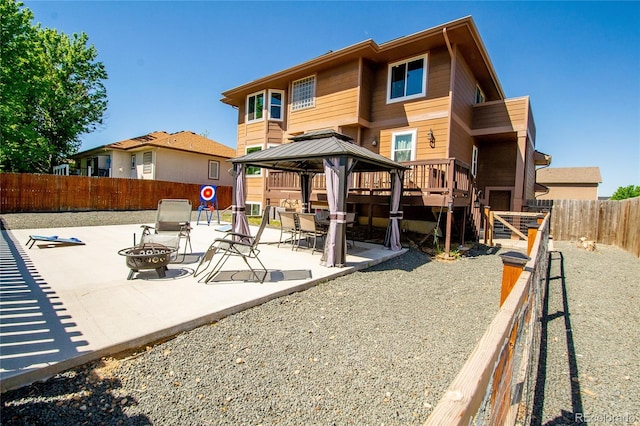 rear view of house featuring a gazebo, a patio area, and an outdoor fire pit