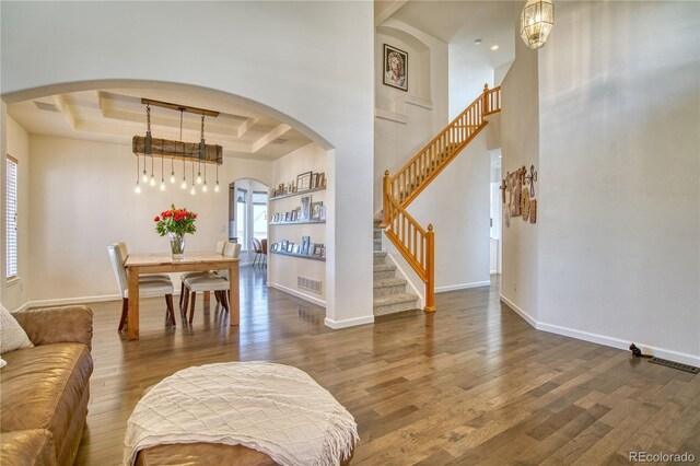 4142 S Deframe Ct, Morrison, CO 80465 - living area with visible vents, arched walkways, wood finished floors, baseboards, and a raised ceiling
