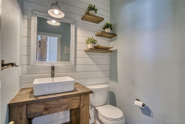 4142 S Deframe Ct, Morrison, CO 80465 - bathroom featuring vanity, a textured wall, wood walls, and toilet