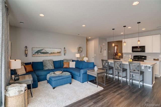 living area with dark wood-type flooring, recessed lighting, and baseboards