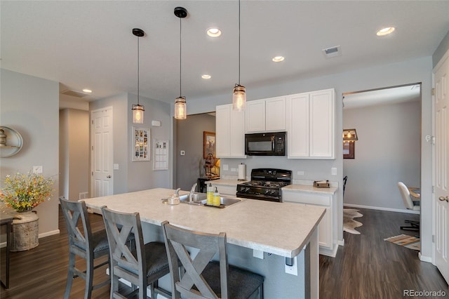 kitchen with black appliances, a sink, baseboards, dark wood-style floors, and recessed lighting