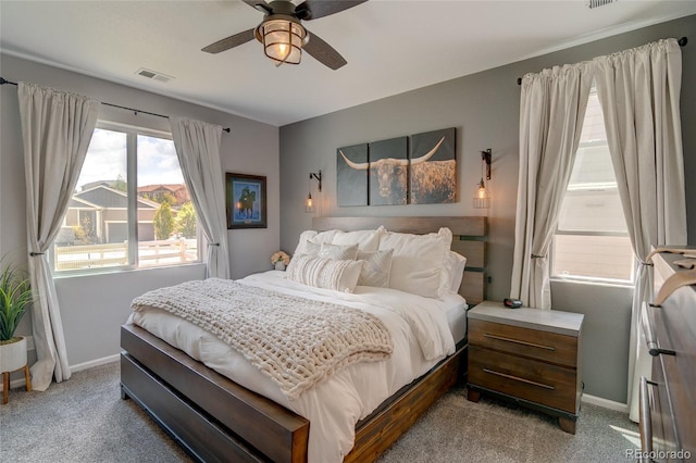 bedroom featuring light colored carpet, baseboards, and a ceiling fan