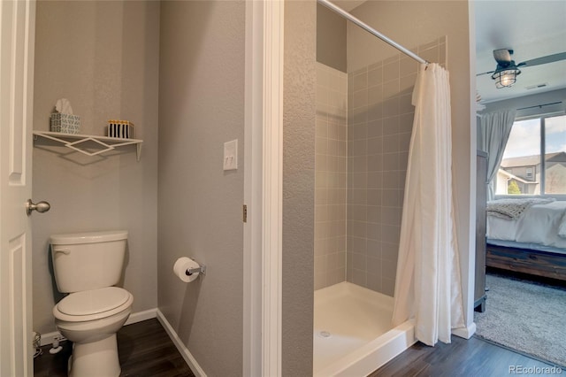 ensuite bathroom featuring wood finished floors, toilet, and a stall shower