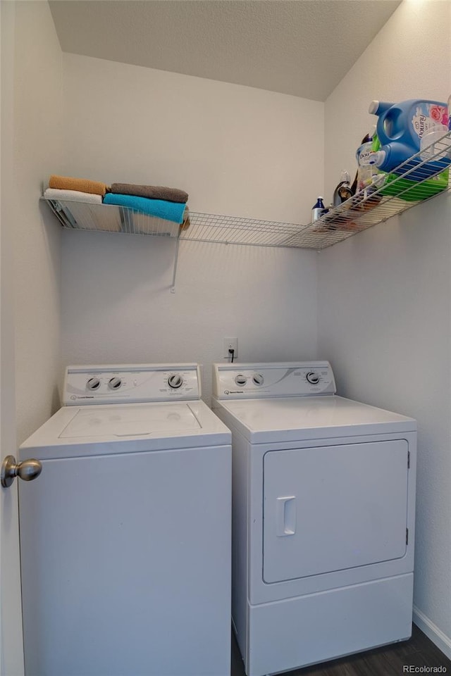 washroom featuring washing machine and clothes dryer, dark wood-type flooring, and baseboards