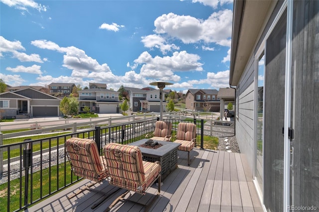 wooden terrace featuring an outdoor fire pit and a residential view