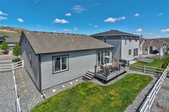 back of property with a wooden deck and a shingled roof