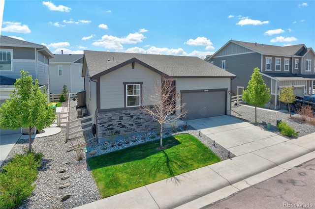 view of front of home featuring driveway, a garage, a residential view, and fence