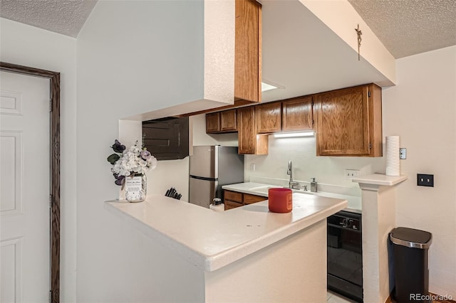 8225 Fairmount Dr Unit 104, Denver, CO 80247 - kitchen with a textured ceiling, a sink, freestanding refrigerator, light countertops, and a peninsula