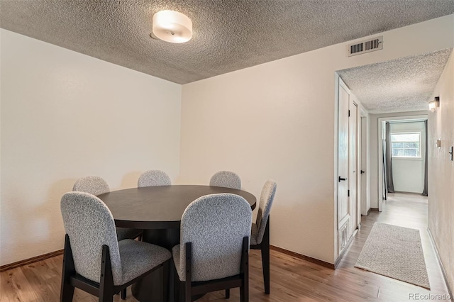 8225 Fairmount Dr Unit 104, Denver, CO 80247 - dining room with a textured ceiling, wood finished floors, and baseboards