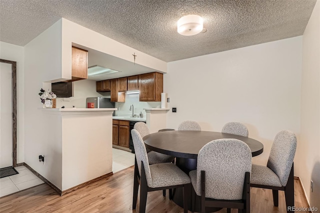 8225 Fairmount Dr Unit 104, Denver, CO 80247 - dining space with light wood-type flooring and a textured ceiling