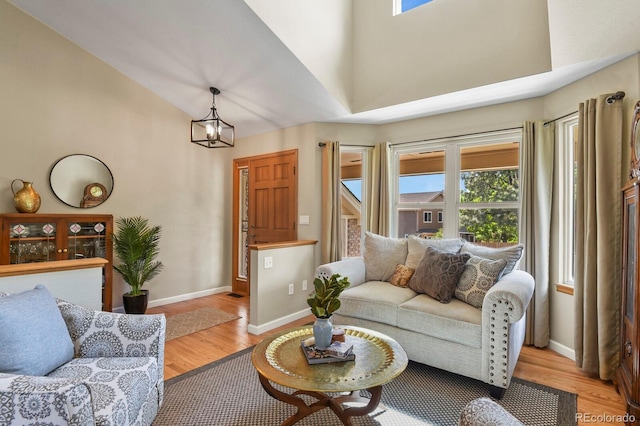 2146 S Ellis Ct, Lakewood, CO 80228 - living room featuring plenty of natural light, wood finished floors, baseboards, and high vaulted ceiling