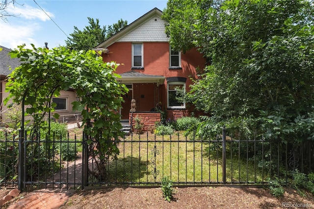 131 Fox St, Denver, CO 80223 - victorian home with a fenced front yard, brick siding, and a gate